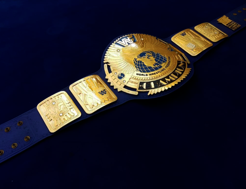 Wrestling championship belt with gold and blue design on a dark background